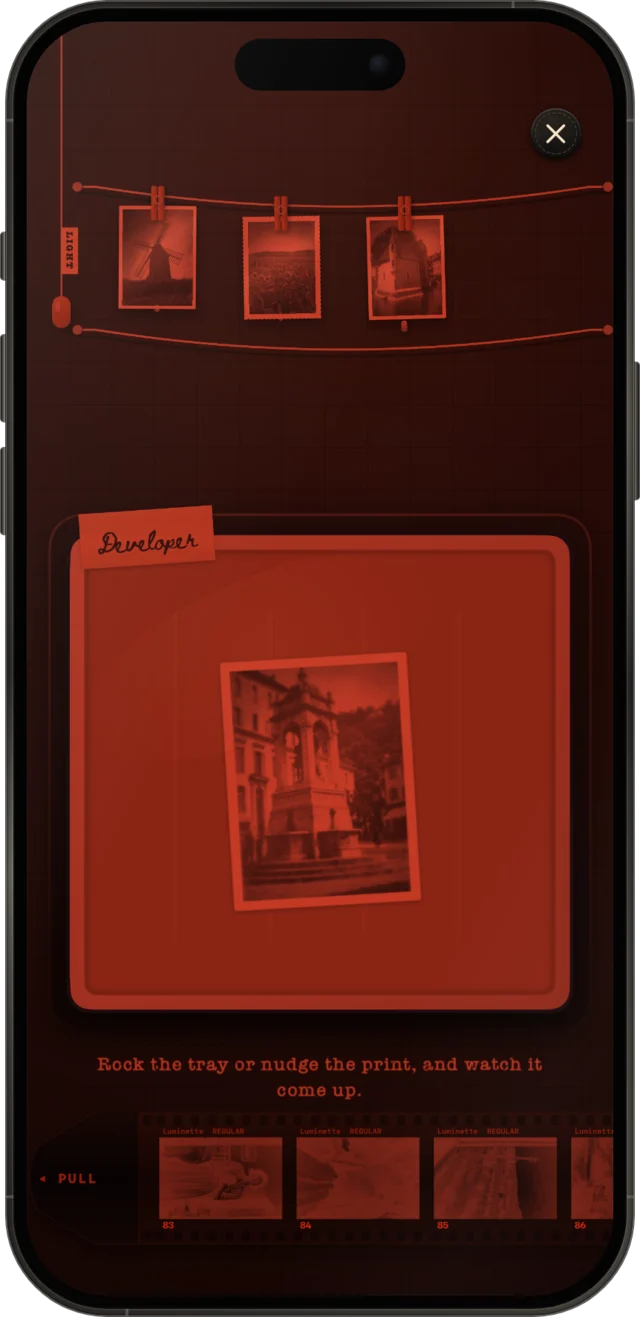 A print coming up in the developing tray under red light, on iPhone.
